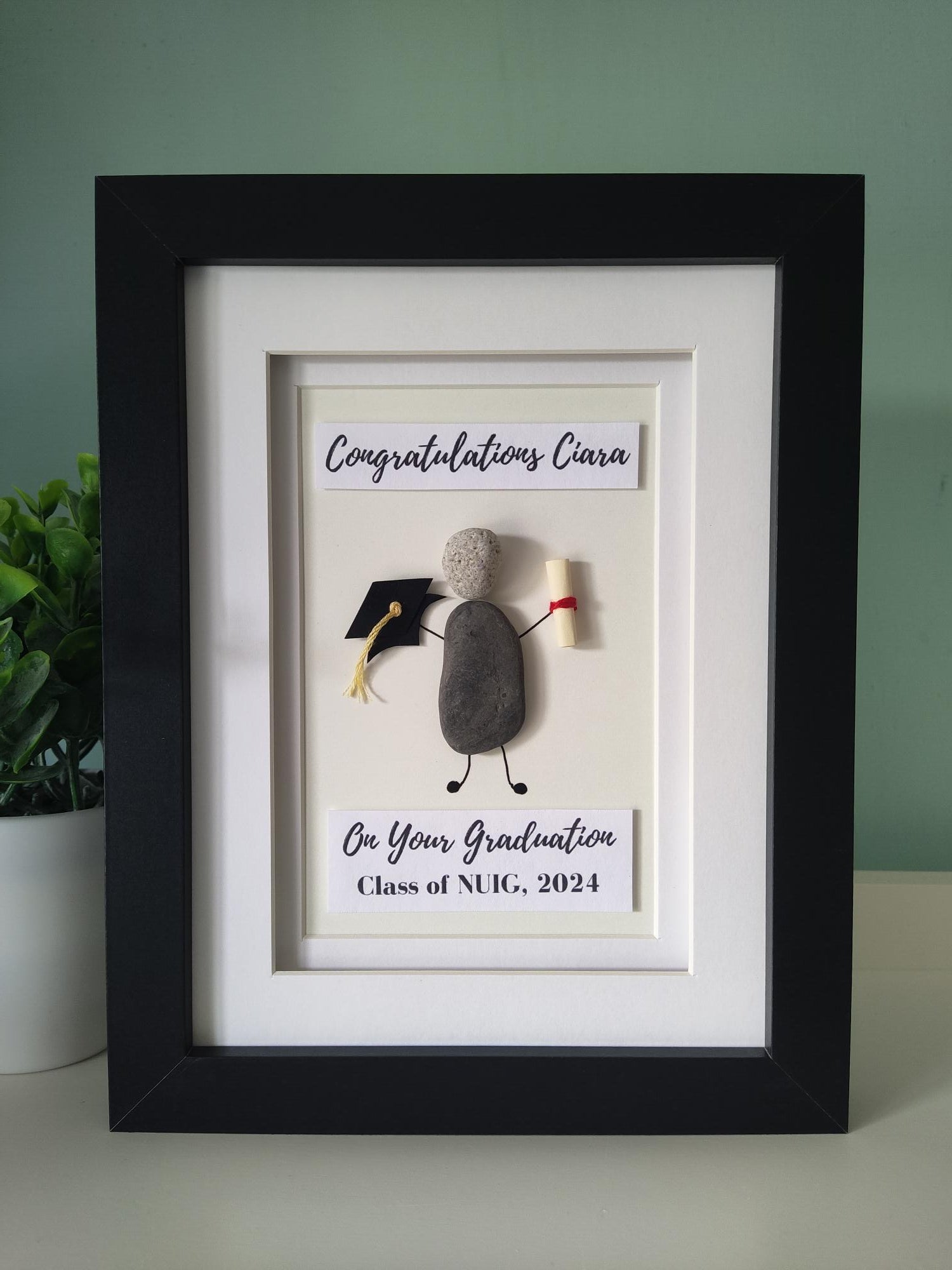 A personalized congratulatory artwork frame, with a graduation cap and a diploma design, and the text 'CONGRATULATIONS ON YOUR GRADUATION CLASS OF 2024'.